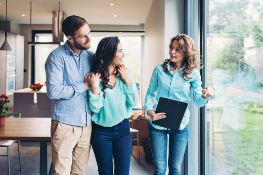 Zwei Personen arbeiten gemeinsam an einem Schreibtisch mit einem Laptop, Papieren und einer Tasse Kaffee.